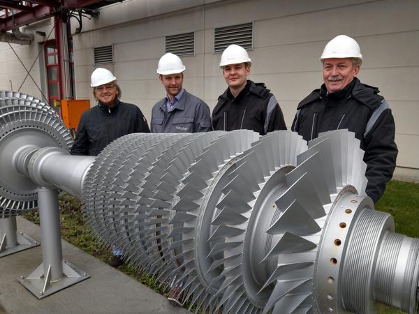 Kraftwerksleiter Uwe Richlak und die Betriebsingenieure Steffen Asmus, Dennis Reincke und Hartmut Beuster (von links) werden Besucher durch das GuD führen. Dabei dient ihnen auch dieser »Läufer« der nach 21 Jahren ausgetauschten Gas-Turbine als Anschauung